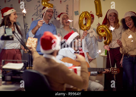 Erfolgreiche Kollegen in Santa Kappen in Weihnachten Spaß im Büro. Stockfoto