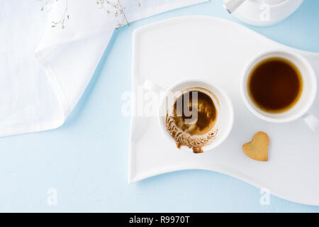 Zwei leere Tassen Kaffee und herzförmige Plätzchen. Stockfoto