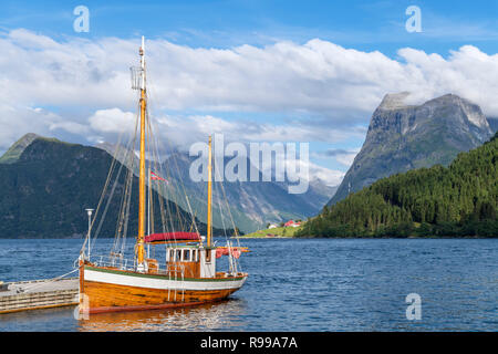 Norwegischen Fjorde. Traditionelle Boot an einen Steg außerhalb der Sagafjord Hotel günstig in den späten Nachmittag, Saebø, Hjørundfjord, Møre og Romsdal, Norwegen Stockfoto