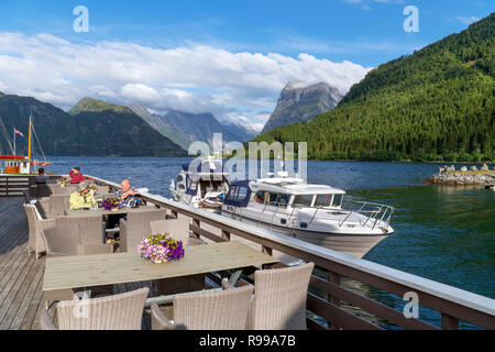 Die Gäste sitzen auf dem Deck der Sagafjord Hotel Bar am späten Nachmittag, Saebø, Hjørundfjord, Møre og Romsdal, Norwegen Stockfoto