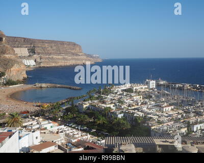Blick über den Strand und Hafen, Klippen und den Atlantik in Puerto de Mogan, Gran Canaria, Kanarische Inseln Stockfoto
