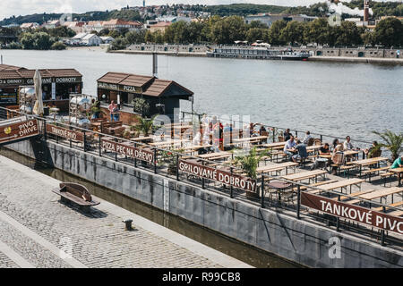 Prag, Tschechische Republik - 23 August, 2018: Die Menschen sitzen an den Tischen des Café an der Moldau in Prag. Die Moldau ist der längste Fluss in der Cze Stockfoto