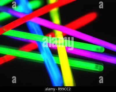 Variation von Bunt bunt farbig fluoreszierende chem Licht Neonröhre mit Reflexion über Spiegel mit schwarzem Hintergrund. Spaß Party Night Konzept Stockfoto