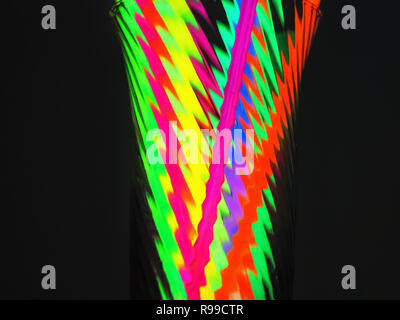 Variation von Bunt bunt farbig fluoreszierende chem Licht Neonröhre mit Reflexion über Spiegel mit schwarzem Hintergrund. Spaß Party Night Konzept Stockfoto