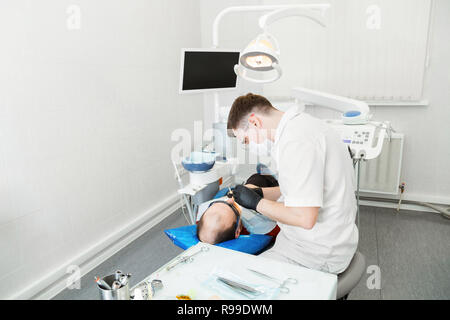 Zahnarzt behandelt die Zähne des Patienten in der Klinik Stockfoto