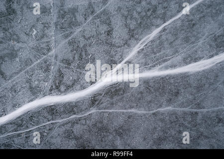 Risse im Eis auf der Oberfläche eines gefrorenen Bergsee Stockfoto