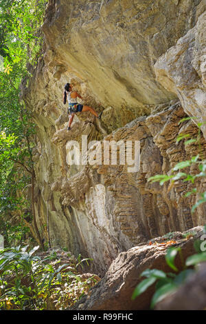 Frau Kletterer führenden einem überhängenden Route in der Nähe von Thakhek Laos Stockfoto