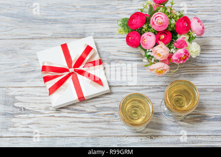 Zwei Gläser Wein, Blumen und ein Geschenk Stockfoto