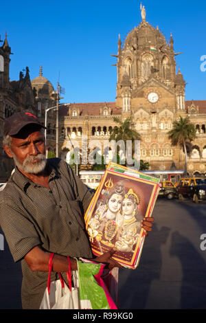 Ein souvenir Verkäufer Chhatrapati Shivaji Maharaj Terminus (Csmt), von der UNESCO zum Weltkulturerbe in Mumbai, Indien, mit einem Bild von hinduistischen Gottheiten Stockfoto