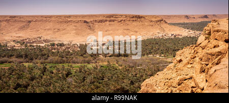 Marokko, Tafilalet region, Ziz Tal, Oasis unter Felsigen Hügeln, Panoramablick Stockfoto