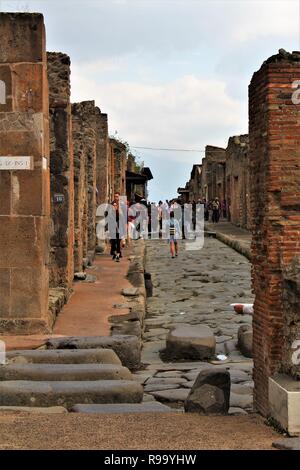 Pompeji, Italien - 23. Oktober 2018: Touristen Erhebung und eine der vielen Straßen innerhalb der Ruinen der antiken Stadt Pompeji zu erkunden. Stockfoto