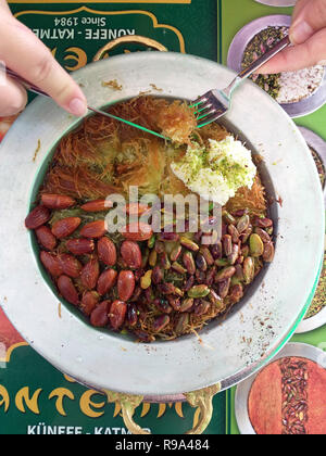 Türkisches Dessert kunefe, kunafa, kadayif mit Pistazien Pulver und Käse heiß gegessen ein süßes Stockfoto