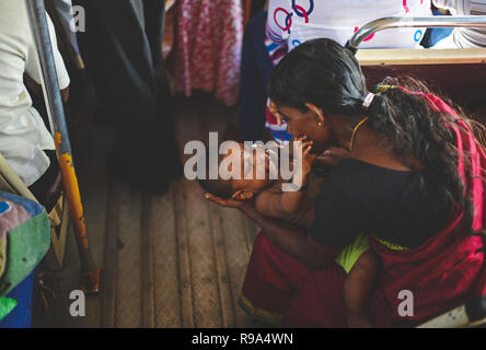 Mutter beruhigt ein Baby in einem öffentlichen Bus, Sri Lanka Stockfoto