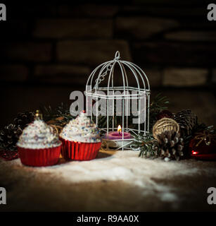 Cupcakes, Weihnachten Kerze und Weihnachtsschmuck auf Holz- ba Stockfoto