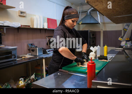 Frau bereitet leckeres Sushi in der Küche im Restaurant Stockfoto