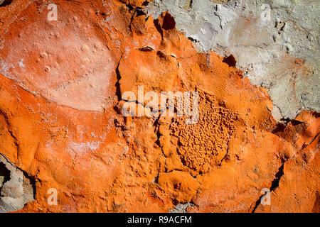 Orange Putz blättert von einer alten Mauer. Alt, dreckig geschält Pflasterwand mit aus fallenden Flocken von Farbe. Textur, Muster, Hintergrund. Stockfoto