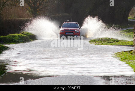 Selmeston, East Sussex, UK. 21 Dez, 2018. Verkehr verhandelt überflutete Straßen in East Sussex nach neuen schweren Regen, East Sussex. Credit: Peter Cripps/Alamy leben Nachrichten Stockfoto