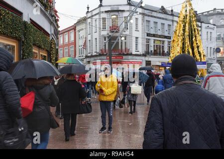 Cork, Irland, 21. Dezember, 2018. Schwere Duschen nicht abschrecken Käufer am letzten Freitag vor Weihnachten, die Stadt Cork. Der Regen, der den ganzen Tag nicht stoppen Käufern aus, Ihre letzten Stücke in der Stadt am letzten Wochenende vor Weihnachten fiel. Die Straßen waren voll von Käufern von Geschäft zu Geschäft hetzen die Vermeidung der Regen, als auch viele Menschen sammeln für wohltätige Organisationen wie z. B. Share und Kork Simon. Credit: Damian Coleman/Alamy Leben Nachrichten. Stockfoto