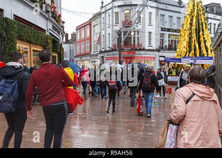 Cork, Irland, 21. Dezember, 2018. Schwere Duschen nicht abschrecken Käufer am letzten Freitag vor Weihnachten, die Stadt Cork. Der Regen, der den ganzen Tag nicht stoppen Käufern aus, Ihre letzten Stücke in der Stadt am letzten Wochenende vor Weihnachten fiel. Die Straßen waren voll von Käufern von Geschäft zu Geschäft hetzen die Vermeidung der Regen, als auch viele Menschen sammeln für wohltätige Organisationen wie z. B. Share und Kork Simon. Credit: Damian Coleman/Alamy Leben Nachrichten. Stockfoto