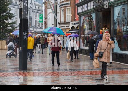 Cork, Irland, 21. Dezember, 2018. Schwere Duschen nicht abschrecken Käufer am letzten Freitag vor Weihnachten, die Stadt Cork. Der Regen, der den ganzen Tag nicht stoppen Käufern aus, Ihre letzten Stücke in der Stadt am letzten Wochenende vor Weihnachten fiel. Die Straßen waren voll von Käufern von Geschäft zu Geschäft hetzen die Vermeidung der Regen, als auch viele Menschen sammeln für wohltätige Organisationen wie z. B. Share und Kork Simon. Credit: Damian Coleman/Alamy Leben Nachrichten. Stockfoto