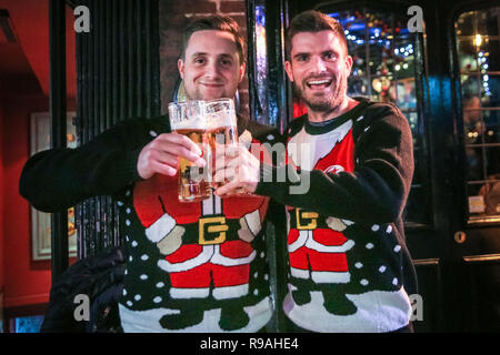 London, Großbritannien. 21. Dez 2018. Zwei junge Männer, die in Weihnachten Jumper geschmückt, feiern das Ende der Arbeitswoche. Londonern und Touristen Masse in Central London auf Was ist der letzte Arbeitstag vor Weihnachten für viele, die sich in der Hauptstadt und einer relativ milden, trockenen Abend für Ende Dezember. Credit: Imageplotter Nachrichten und Sport/Alamy leben Nachrichten Stockfoto