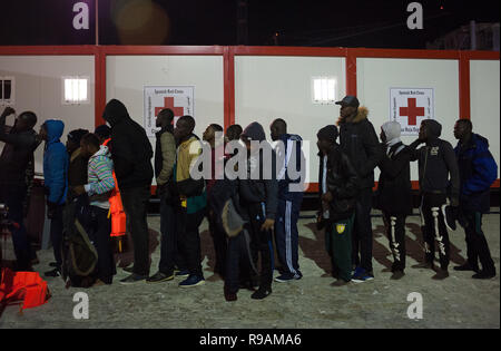 Malaga, Spanien. 22 Dez, 2018. Migranten gesehen, die in der Warteschlange warten, um einen humanitären Notstand Stall nach Ihrer Ankunft im Hafen von Malaga. Spaniens Maritime Rescue Service gerettet 113 Migranten an Bord Jollen auf der Alboran See, und brachte sie nach Malaga Hafen, von wo aus sie durch das Spanische Rote Kreuz unterstützt wurden. Credit: Jesus Merida/SOPA Images/ZUMA Draht/Alamy leben Nachrichten Stockfoto