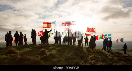 Lockerbie, Schottland, Großbritannien. 22. Dezember, 2018. Ein Spaziergang für den Frieden bis Burnswark in der Nähe von Lockerbie in Erinnerung an diejenigen, die in der Katastrophe von Lockerbie enthalten. Der Weg folgt der jahrhundertealten Tradition in Schottland, zu den Hügeln, Frieden zu finden und die Zukunft nachzudenken. Der Spaziergang bis Burnswark mit den Flaggen der 21 Nationen, die Opfer von der Pan Am Flug 103 aus wurde organisiert von Vertretern von allanton Welt Frieden Sanctuary und lokale Künstler Credit: Allan Devlin/Alamy Live Nachrichten kamen Stockfoto