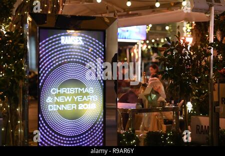 Madrid, Spanien. 21 Dez, 2018. Die Menschen genießen, sich in ein Restaurant im Freien in Madrid, die Hauptstadt Spaniens, Dez. 21, 2018. Weihnachtsbeleuchtung die Hauptstraßen von Madrid beleuchten, läutet den Start von Weihnachten und Neujahr feiern. Quelle: Guo Qiuda/Xinhua/Alamy leben Nachrichten Stockfoto