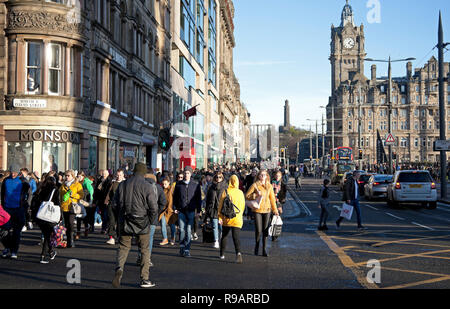 Edinburgh, Schottland, Großbritannien. 22. Dezember 2018, Super Samstag an der Princes Street in der schottischen Hauptstadt, tausende von Menschen auf die Gehwege und Straßen aber nicht viele Einkaufstaschen für diese letzte Wochenende vor Weihnachten. Obwohl die Einzelhändler haben eine beispiellose Menge an Vorweihnachtlichen Umsatz ein abschließendes Angebot für Käufer Geld ins Leben gerufen. Einige der jüngeren Generation für die Eisbahn in St. Andrew's Square, anstatt den Einkaufsstraßen entschieden. Stockfoto