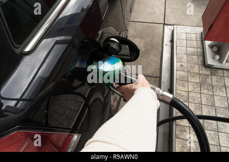 Weibliche Hand füllen Benzin in einem Auto mit Gas Pumpe Düse Stockfoto