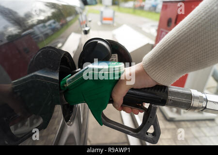 Weibliche Hand füllen Benzin in einem Auto mit Gas Pumpe Düse Stockfoto