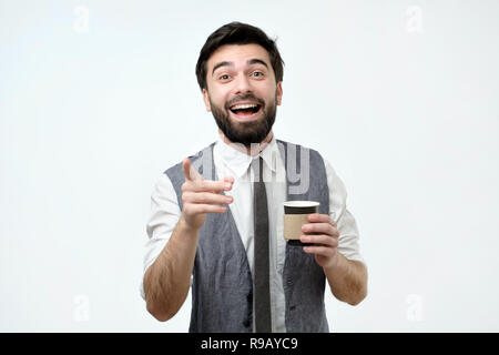 Junge Hispanic Mann, der auf Sie eine Tasse mit Kaffee Stockfoto