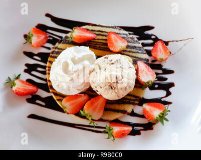 Erdbeere Pfannkuchen Chocolate Chip Eis/Dessert frische Erdbeeren Obst auf Pfannkuchen mit Vanilleeis und Sahne gießen c Stockfoto