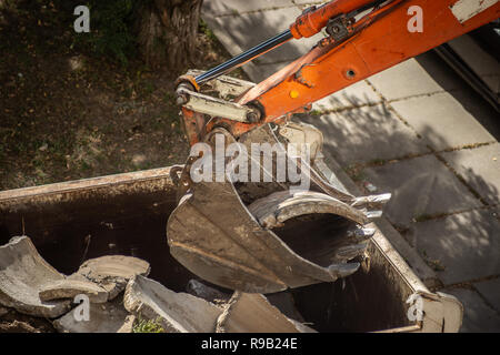 Demontage der alten konkrete Strukturen mit einem Bagger. Schöpfkelle close-up. Stockfoto