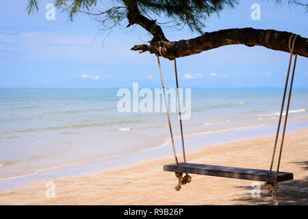 Holz- Schwingen hängen von einem Baum am Strand. Ein tropischer Strand im südlichen Teil von Thailand in sonniger Tag. Stockfoto