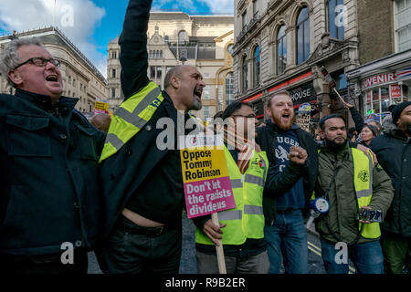 Ein Mann steigt seine Faust und riefen Slogans in gedrängten Gruppe während Anti rechts Protest in Central London, Dezember 2018, UK. Stockfoto