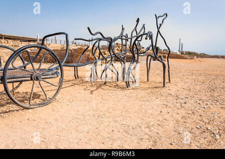 Caesarea, Israel - 22. Mai 2012: Moderne Skulpturen der römischen Pferd Wagen der Schwarz gebogen geschmiedete Metallständer auf antiken Caesarea Strand, wo lange ti gemacht Stockfoto