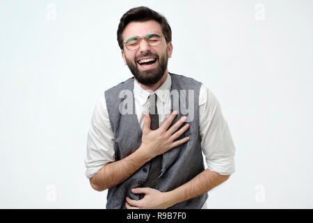 Spanischer Mann mit einem Bart lacht Holding auf den Bauch Stockfoto