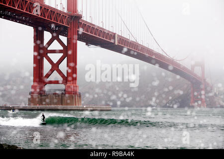 USA, Kalifornien, San Francisco, ein Surfer Fänge eine Welle am Fort Point unter der Golden Gate Bridge Stockfoto