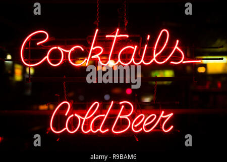 Blick auf Vintage ocktails und kaltes Bier Leuchtreklame hängen in einem bar Fenster Stockfoto