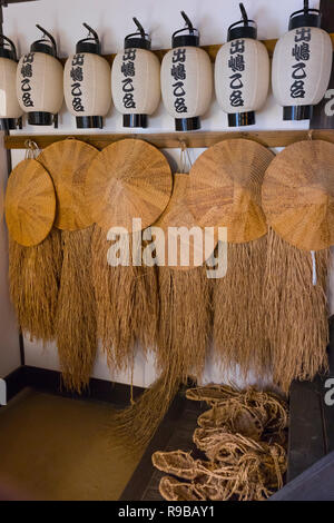 Nagasaki, Japan - Oktober 22, 2018: Historische Strohhüte, Sandalen und Papierlaternen in der Rekonstruktion der Gebäude in Dejima ausgestellt Stockfoto