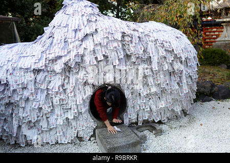Mädchen kriecht durch die Tunnel der Wahrsagerei Papier rutscht, Gion, Kyoto, Japan Stockfoto