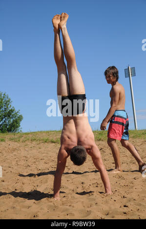 Kovrov, Russland. 12. Juli 2014. Nachbarschaften der Stadt Kovrov, See Starka (Krivoe). Jugendlich tun handstand am Strand der See Stockfoto