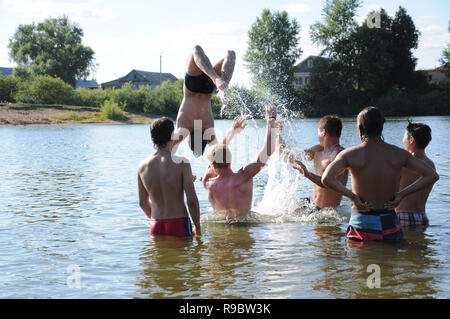 Kovrov, Russland. 12. Juli 2014. Nachbarschaften der Stadt Kovrov, See Starka (Krivoe). Teens werfen einander beim Schwimmen im See Stockfoto