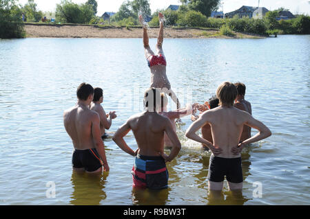 Kovrov, Russland. 12. Juli 2014. Nachbarschaften der Stadt Kovrov, See Starka (Krivoe). Teens werfen einander beim Schwimmen im See Stockfoto