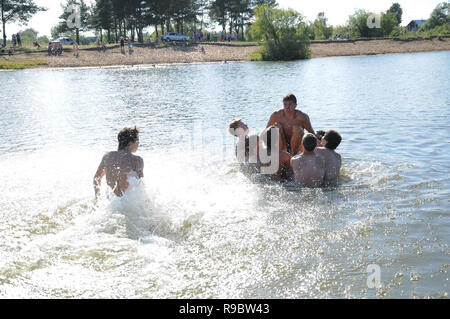 Kovrov, Russland. 12. Juli 2014. Nachbarschaften der Stadt Kovrov, See Starka (Krivoe). Teens werfen einander beim Schwimmen im See Stockfoto