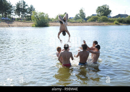 Kovrov, Russland. 12. Juli 2014. Nachbarschaften der Stadt Kovrov, See Starka (Krivoe). Teens werfen einander beim Schwimmen im See Stockfoto