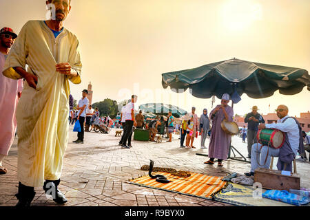 Street Scene mit Schlangen Charmeur und Musikern in Djemaa el Fna Marktplatz in der Medina von Marrakesch. Marrakesch, Marokko, Nordafrika Stockfoto