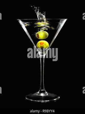 Spritzer Green Olive im Martini Glas auf schwarzem Hintergrund Stockfoto
