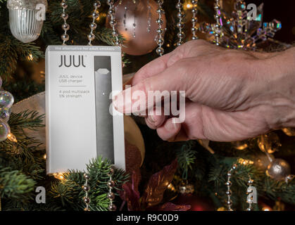 Box holding JUUL Nikotin Dispenser und Hülsen am Weihnachtsbaum Stockfoto